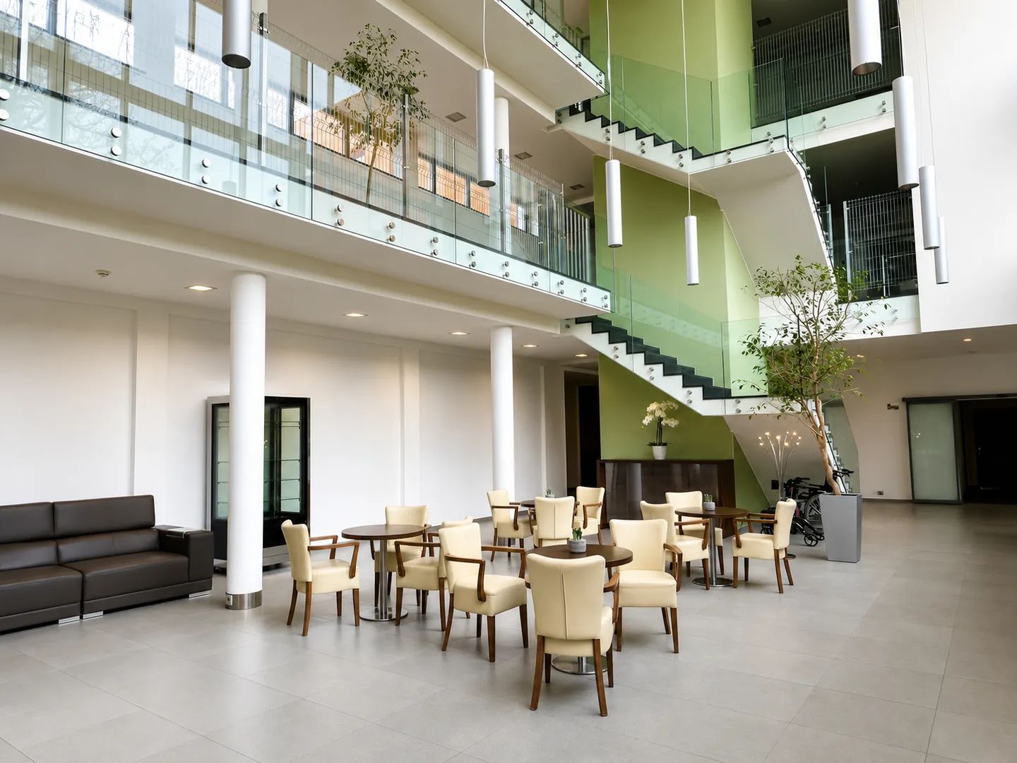 Atrium se schodištěm, zelení a posezením